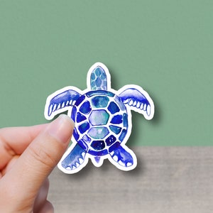 May include: A blue and purple watercolor sea turtle sticker. The turtle has a detailed shell and flippers.