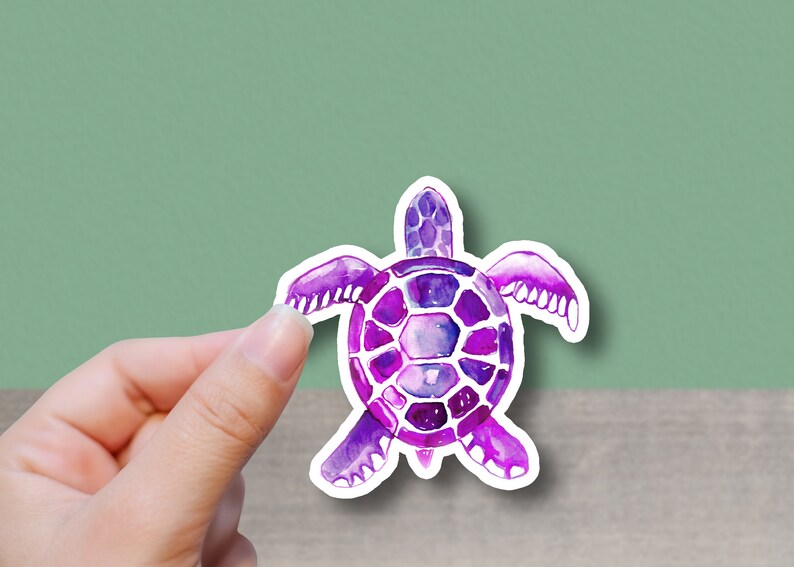 May include: A purple watercolor sea turtle sticker with a white outline. The turtle is facing the viewer with its head and legs visible.