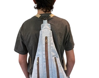 Denim backpack in light blue, three zipper pockets, one back slide-in pocket, adjustable, detachable straps, repurposed jean, no waste