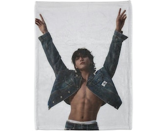 May include: A man wearing a denim jacket with the Calvin Klein logo on the pocket, with his arms raised in the air. He is wearing underwear and jeans.