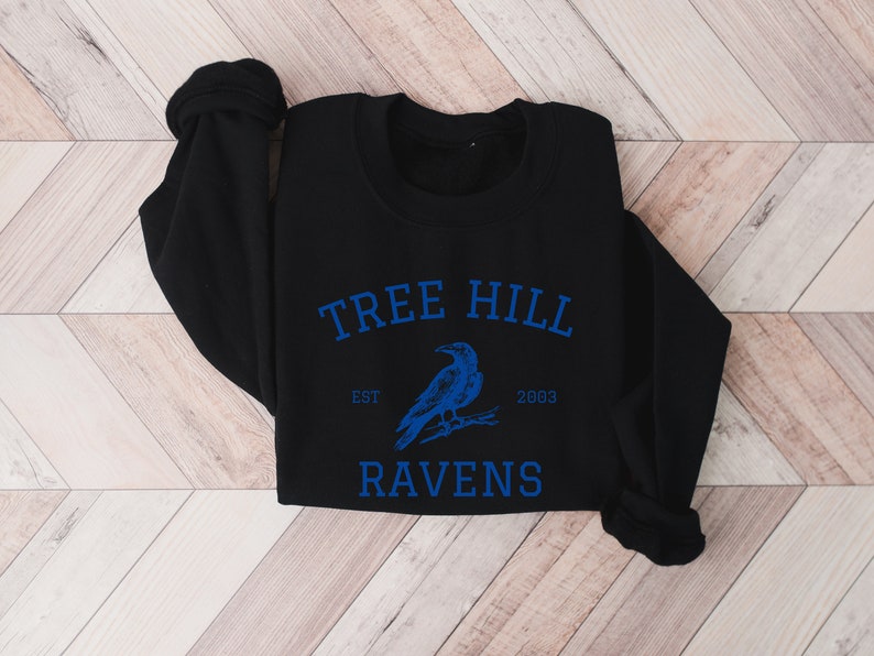 May include: Black sweatshirt with a blue graphic of a raven and the text "Tree Hill Est 2003 Ravens".