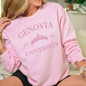 May include: Pink sweatshirt with the text "GENOVIA UNIVERSITY EST 2001" and a crown graphic.