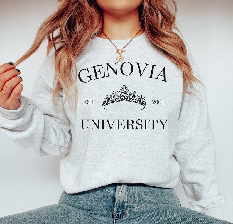 May include: A light grey sweatshirt featuring the words "GENOVIA UNIVERSITY" in black, with a crown graphic and the text "EST 2001". The sweatshirt is a relaxed fit and suitable for everyday wear.