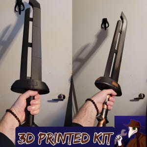 May include: A 3D printed kit of a sword with a dark gray blade and a black handle. The handle has gold and brown accents. The text "3D PRINTED KIT" is at the bottom of the image.