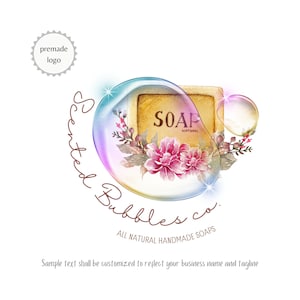Könnte beinhalten: Ein Logo für eine Seifenfirma namens "Scented Bubbles Co." mit dem Text "All Natural Handmade Soaps". Das Logo zeigt eine Aquarell-Illustration einer Seife in einer Blase mit Blumen und Blättern.