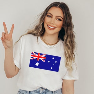 May include: White t-shirt featuring the Australian flag, a blue rectangle with the Union Jack in the upper left corner and white stars. The shirt is a casual style.