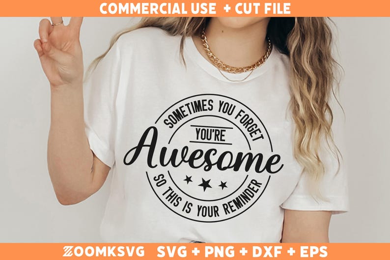 Op de afbeelding: Wit T-shirt met een zwarte cirkelvormige afbeelding met de tekst "Soms vergeet je dat je geweldig bent, dus dit is een herinnering".