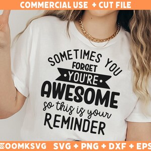 Op de afbeelding: Wit T-shirt met zwarte tekst die luidt: "Soms vergeet je dat je geweldig bent, dus dit is een herinnering".