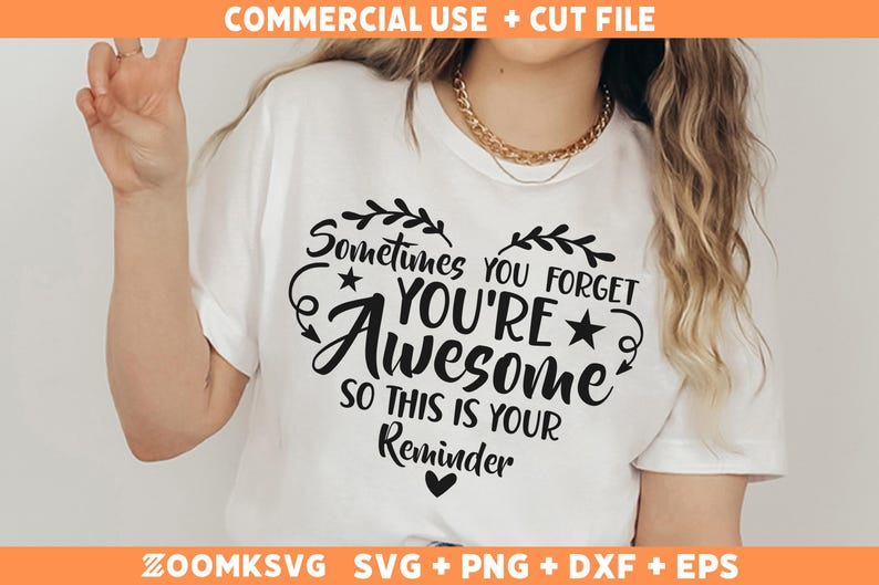 Op de afbeelding: Wit T-shirt met een zwart hartontwerp met de tekst "Soms vergeet je dat je geweldig bent, dus dit is een herinnering".
