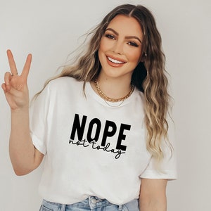 Op de afbeelding: Wit T-shirt met zwarte tekst die "NOPE not today" zegt.