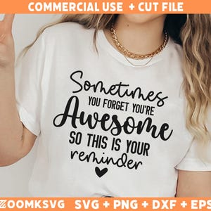 Op de afbeelding: Wit T-shirt met zwarte tekst die "Sometimes you forget you're Awesome so this is your reminder" luidt. Een klein hartje bevindt zich onder de tekst.