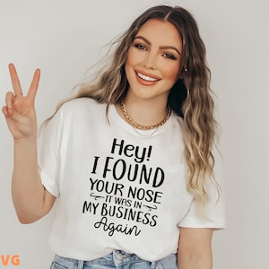 May include: A white t-shirt with black text that reads "Hey! I FOUND YOUR NOSE - IT WAS IN MY BUSINESS Again".