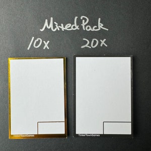 May include: Two blank card templates, one with a gold border and the other with a black border. The text "Mixed Pack" is written in white above the cards. The text "10x" is written in white to the left of the gold card and the text "20x" is written in white to the right of the black card. The text "TinkerTownGames" is written in white at the bottom of each card.