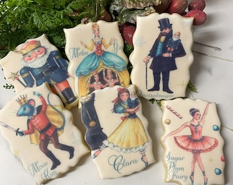 Puede incluir: Seis galletas de azúcar decoradas con personajes del ballet El Cascanueces. Las galletas están decoradas con imágenes de Clara, la Hada de Azúcar, el Rey Ratón, Madre Jengibre, Drosselmeyer y el Cascanueces.