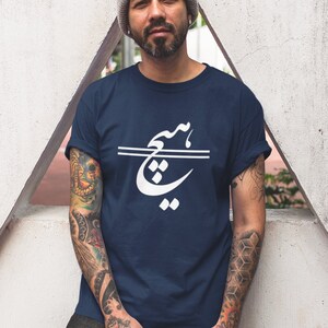 May include: A navy blue t-shirt with a white graphic design of Arabic calligraphy. The design features a stylized word in white with a double line underneath.