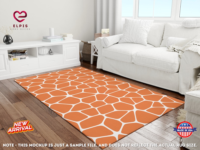 May include: Orange and white geometric patterned area rug with a white couch in the background. The rug has a modern design with a honeycomb pattern.