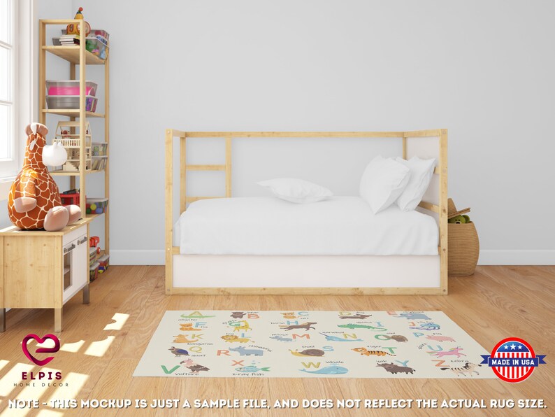 May include: A white and beige alphabet rug with colorful animal illustrations. The rug features the letters A through Z with a corresponding animal for each letter. The rug is laid out on a wooden floor in a room with a white wall, a wooden bed frame, and a wooden shelf.