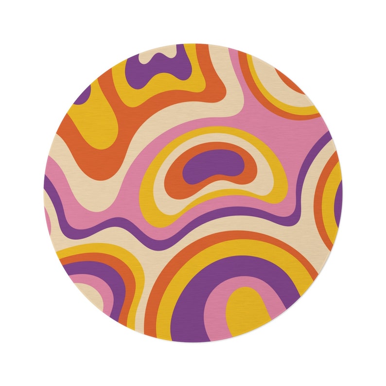 May include: A round, retro-style rug with a swirling pattern in shades of orange, yellow, purple, and pink. The design features a cream-colored background with curved lines, creating a groovy, psychedelic aesthetic. The rug is a circular shape.