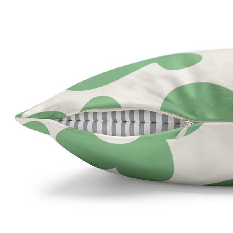 May include: A green and white throw pillow with a zipper closure. The pillow has a pattern of large green circles on a white background.