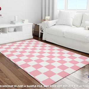 May include: Pink and white checkered area rug with a white background and pink squares. The rug is laid out on a hardwood floor in a living room setting.