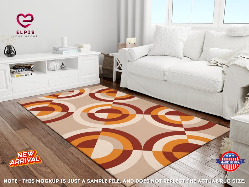 May include: A geometric patterned rug with orange, brown, and white circles and squares on a beige background. The rug is laid out on a wooden floor in a living room setting.