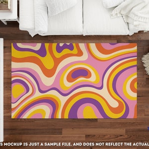 May include: A colorful area rug with a retro design. The rug features a swirling pattern in shades of pink, orange, yellow, purple, and cream. The rug is rectangular and appears to be made of a soft material. The rug is placed on a dark wood floor.