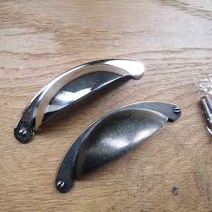 May include: Two cabinet pulls, one in polished chrome and one in antique nickel, with screws included.