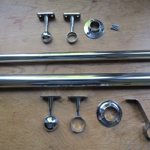 May include: A set of chrome curtain rod hardware, including two rods, four finials, two brackets, two end caps, and two rings. The hardware is designed for a double curtain rod.