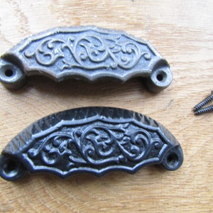May include: Two ornate cast iron drawer pulls with a floral design. One pull is black and the other is a silver colour. Both pulls come with two screws.