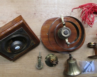 May include: A vintage doorbell kit with a wooden base, a brass bell, a pull button, and a red cord. The kit includes all the necessary hardware for installation.