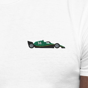Könnte beinhalten: Weißes T-Shirt mit einem kleinen, gestickten grünen und schwarzen Rennwagen-Design auf der Brust. Der Rennwagen hat die Nummer 14. Das Shirt ist aus weichem Material.