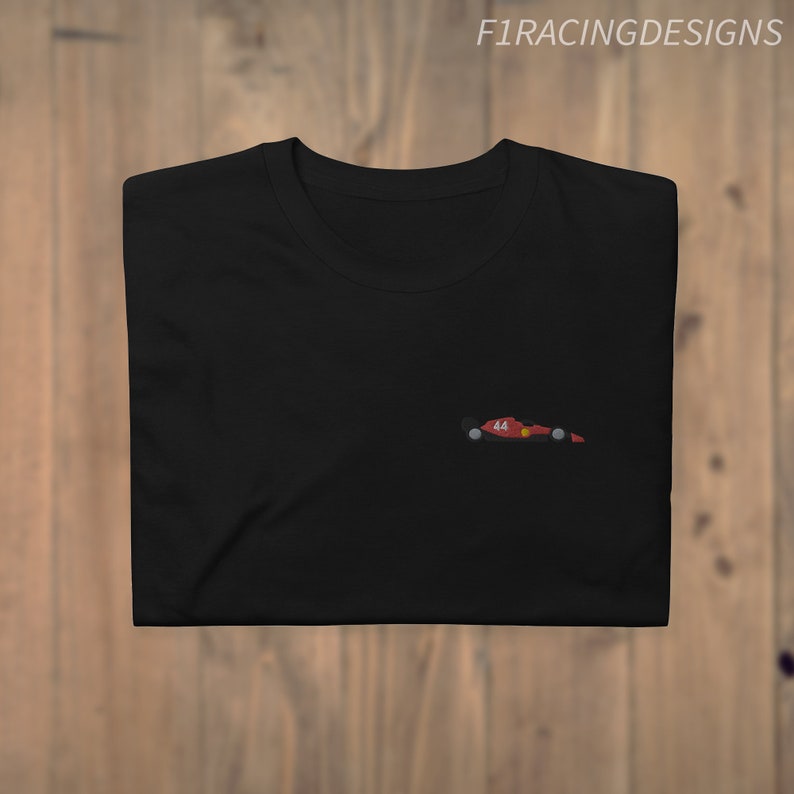 May include: Black t-shirt with a small red and black race car graphic on the left chest. The car has the number 44 on it.
