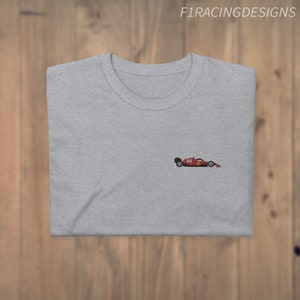 May include: A grey t-shirt with a small embroidered image of a red racing car with the number 14 on the side.
