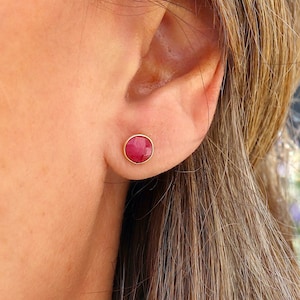 Peut inclure: Une paire de boucles d'oreilles en or avec une pierre rouge ronde.