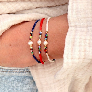 Peut inclure: Trois bracelets en perles avec des accents de perles. Les bracelets sont rouge, blanc et bleu avec des perles colorées.