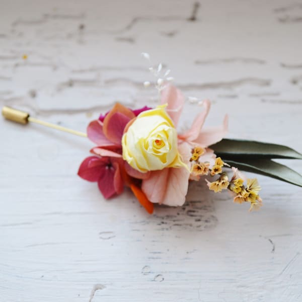 Boutonnière mariage fleurs stabilisées colorées fuchsia, orange et feuilles d’olivier- bijoux mariage collection flamenco