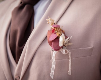 Boutonnière mariage eucalyptus, hortensias ivoire, bordeaux, rouge et gypsophiles jaunes – mariage d’automne