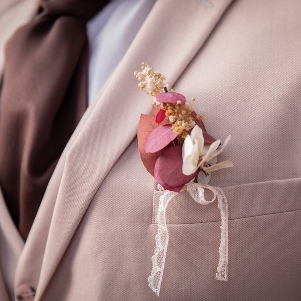 Boutonnière mariage eucalyptus, hortensias ivoire, bordeaux, rouge et gypsophiles jaunes – mariage d’automne