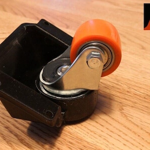 Op de afbeelding: Een zwarte kunststof zwenkwiel met een oranje polyurethaan wiel. Het wiel heeft een metalen lager en een zilveren metalen beugel.