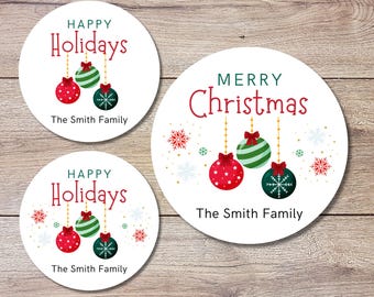 May include: Three round white gift tags with red and green Christmas ornaments, snowflakes, and the text "Happy Holidays" and "Merry Christmas". Each tag also includes the text "The Smith Family".