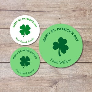 Puede incluir: Tres pegatinas redondas con un diseño de trébol y el texto "Happy St. Patrick's Day". Una pegatina es blanca con el texto "Your Friend, Amelia". Una pegatina es verde con el texto "From William". Una pegatina es verde con el texto "Your Friend, Amelia".