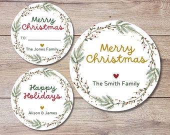 Könnte beinhalten: Drei runde Weihnachtsgeschenkanhänger mit festlichen Designs. Die Anhänger zeigen Texte wie "Merry Christmas" und "Happy Holidays", umgeben von einem Kranz aus Grün und Beeren. Ein Anhänger enthält "The Jones Family", ein anderer "The Smith Family" und der dritte "Alison & James".