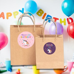 May include: Two brown paper gift bags with handles. The bags have colorful unicorn stickers with the text "Alison's 5th Birthday" and "Happy 8th Birthday Zoe".