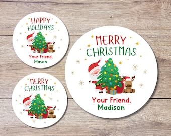 May include: Three white, round Christmas stickers with festive designs. Each sticker features a Christmas tree, Santa Claus, and a reindeer. Text includes "Happy Holidays" and "Merry Christmas", along with personalized names.