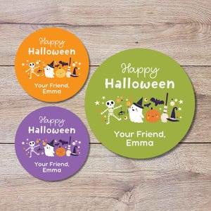 May include: Three circular stickers in orange, green, and purple featuring the text Happy Halloween and Your Friend, Emma. Each sticker displays a skeleton, a ghost, a pumpkin, a broom, a witch hat, a spider, and bats on a solid background.