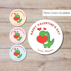 May include: Three round Valentine's Day stickers featuring a cartoon dinosaur holding a heart. The stickers have a white background with red, green, and pink accents. The text on the stickers reads "Happy Valentine's Day", "Love, Mason", "Love, Sophia", and "From Oliver".