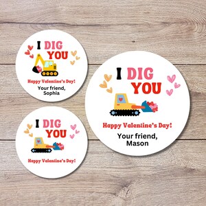 May include: Three white circular stickers with a Valentine's Day theme. Each sticker features a yellow excavator with a heart-shaped bucket, the text "I DIG YOU," and the message "Happy Valentine's Day!" with a name.