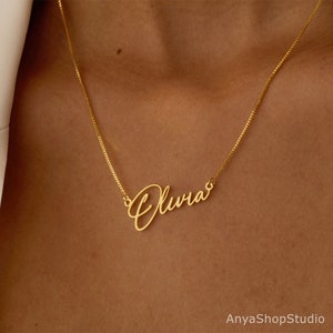 May include: Gold necklace with a cursive nameplate that reads "Olivia".