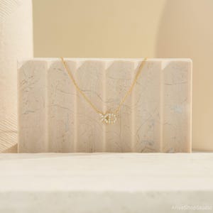May include: A gold chain necklace with a small, diamond-encrusted fish pendant.