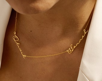 May include: Gold necklace with two names, "Olivia" and "Hannah", written in cursive script.